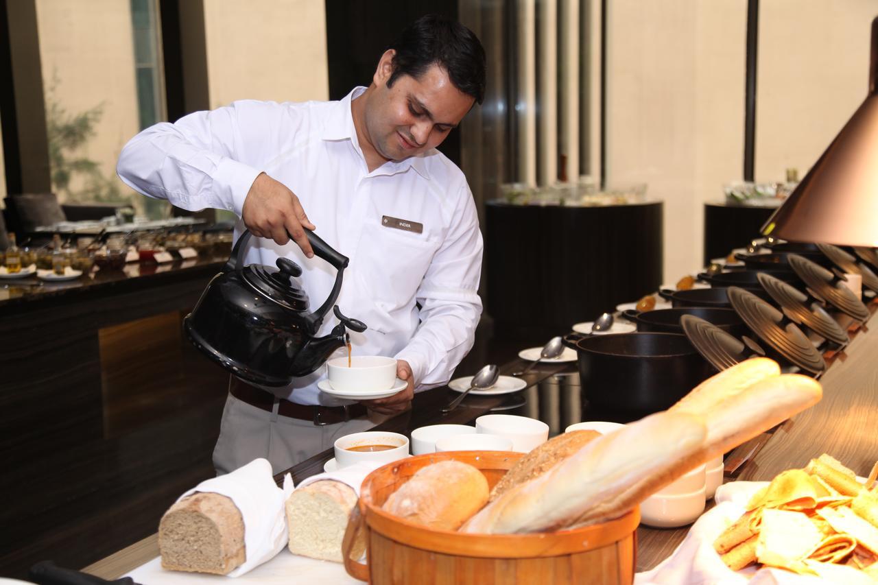Roseate House New Delhi Nova Deli Exterior foto A waiter serving masala tea